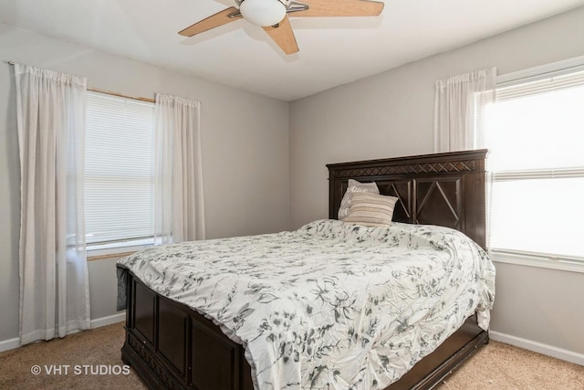 carpeted bedroom featuring multiple windows and ceiling fan