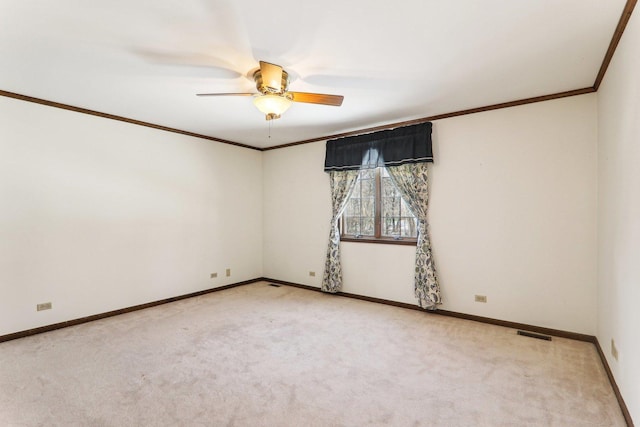 carpeted empty room featuring crown molding and ceiling fan