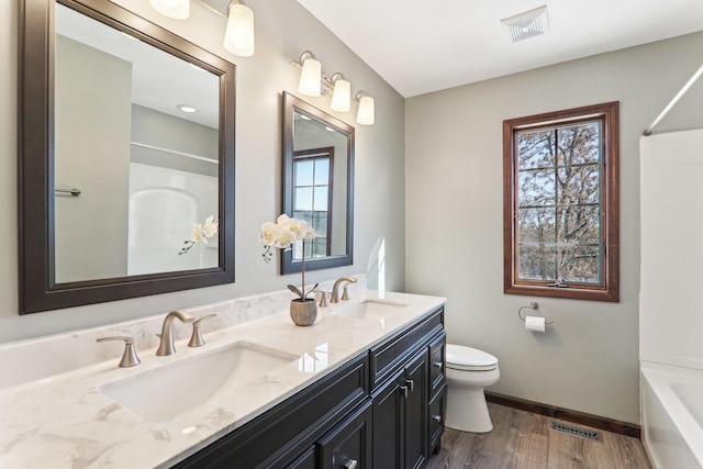 full bathroom featuring vanity, hardwood / wood-style floors, tub / shower combination, and toilet