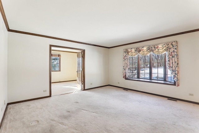 spare room with crown molding and light colored carpet