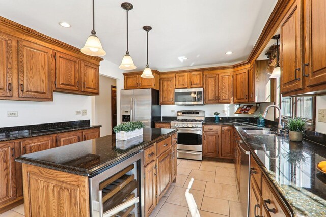 kitchen with decorative light fixtures, a kitchen island, a wealth of natural light, and appliances with stainless steel finishes