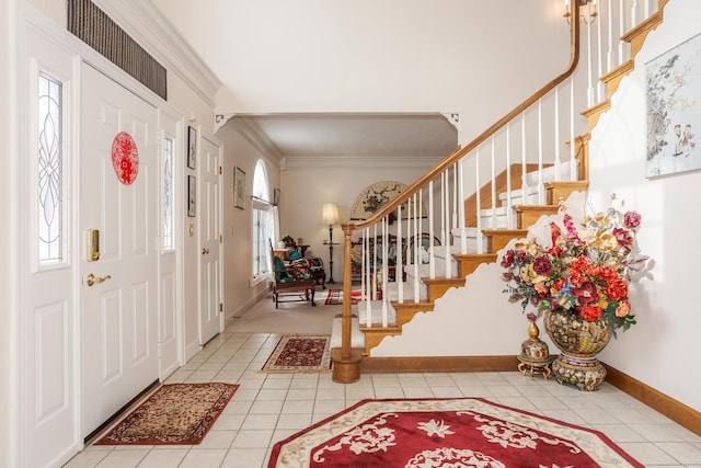 tiled entrance foyer featuring ornamental molding and a wealth of natural light