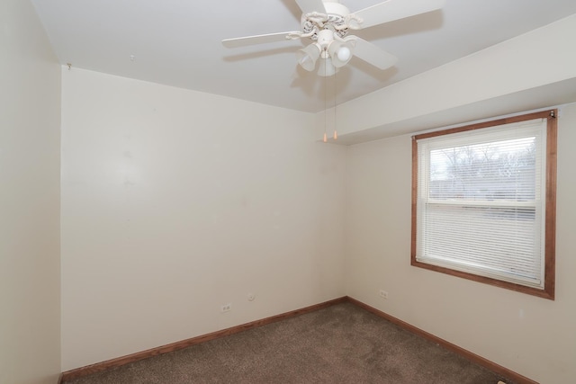 spare room featuring dark carpet and ceiling fan