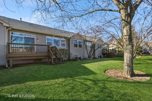 back of house featuring a wooden deck and a yard