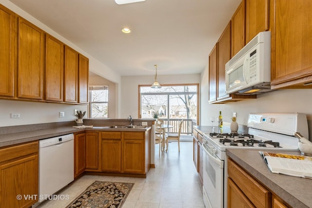 kitchen with pendant lighting, sink, and white appliances