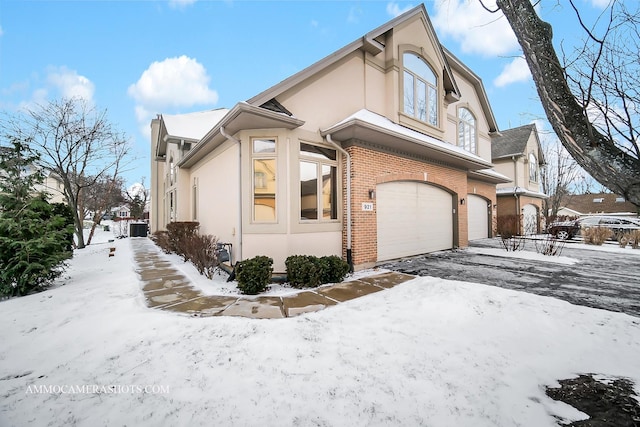 snow covered property with a garage