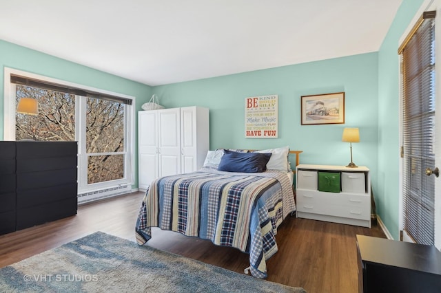 bedroom with hardwood / wood-style floors, a closet, and a baseboard heating unit