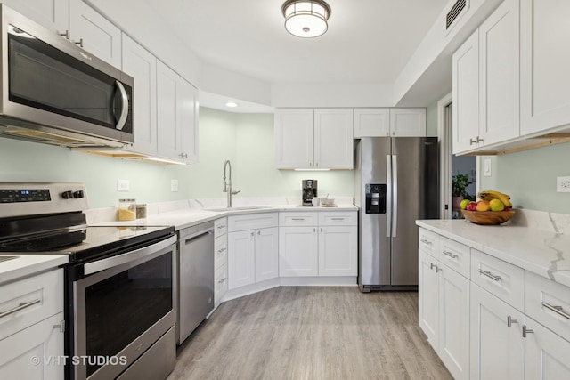 kitchen with appliances with stainless steel finishes, sink, and white cabinets