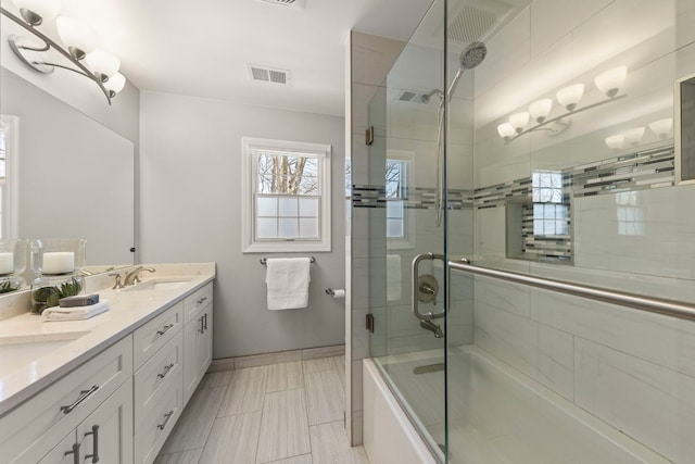 bathroom with vanity and combined bath / shower with glass door