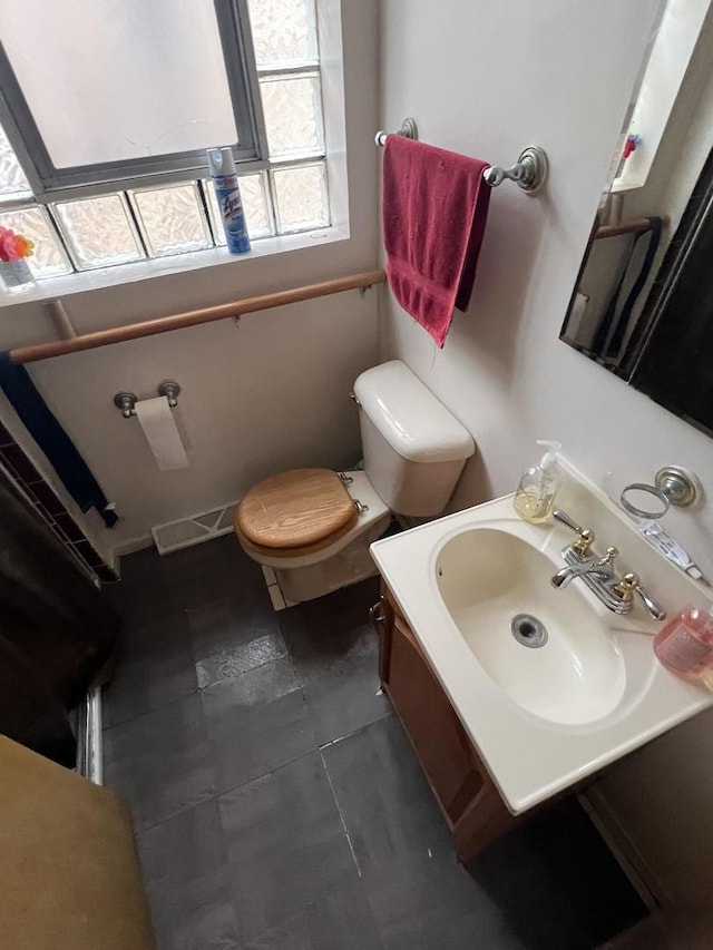 bathroom with tile patterned flooring, vanity, and toilet