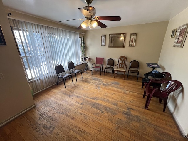 living area featuring hardwood / wood-style floors and ceiling fan