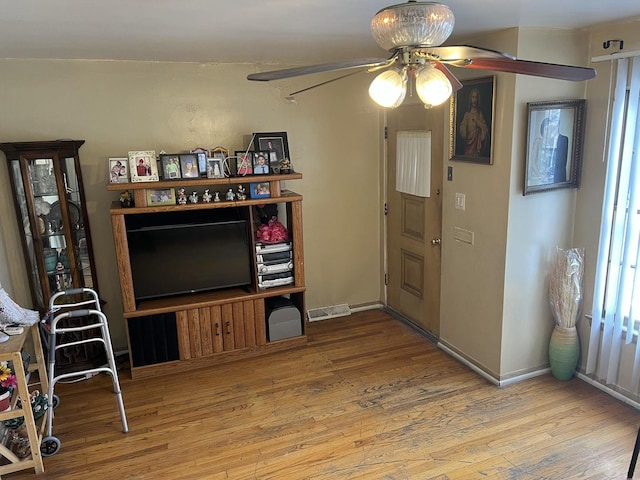 living room featuring wood-type flooring and ceiling fan