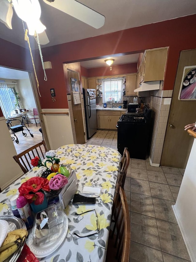 tiled dining room with sink and ceiling fan