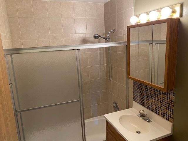 bathroom with enclosed tub / shower combo and vanity