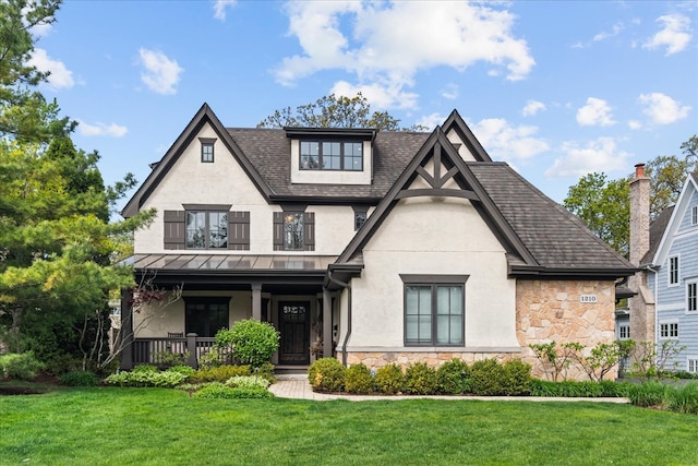 1210 Blackthorn Ln, Deerfield, IL 60015 - view of front facade featuring stone siding, a porch, a front yard, stucco siding, and a standing seam roof