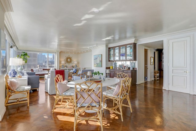 dining space featuring ornamental molding, plenty of natural light, dark parquet floors, and rail lighting