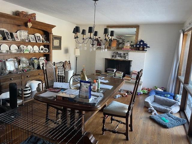 dining area with an inviting chandelier, hardwood / wood-style flooring, and a textured ceiling