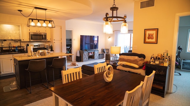 dining room featuring dark colored carpet, sink, and wine cooler