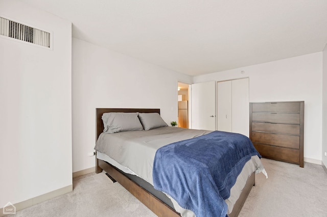 bedroom featuring light colored carpet and a closet