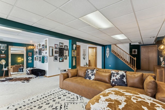 carpeted living room with a paneled ceiling