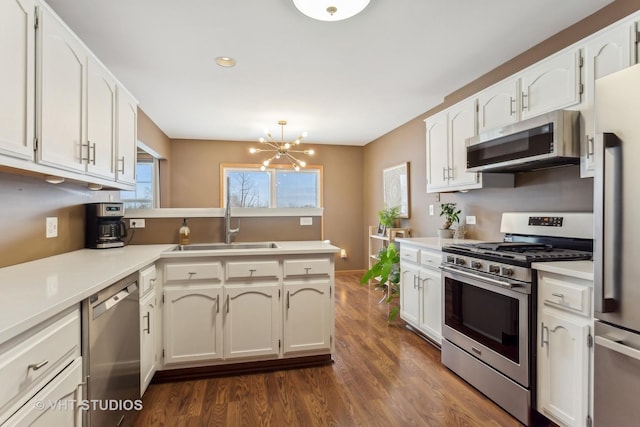 kitchen with appliances with stainless steel finishes, sink, and white cabinets