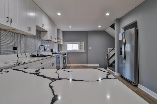 kitchen featuring sink, white cabinetry, stainless steel appliances, dark hardwood / wood-style floors, and light stone countertops