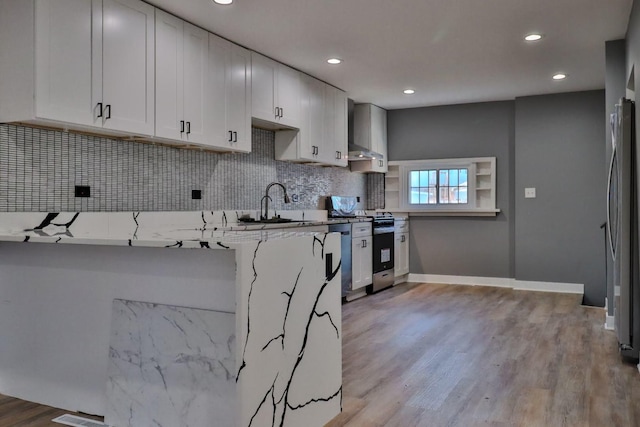 kitchen featuring a kitchen breakfast bar, kitchen peninsula, white cabinets, and light wood-type flooring