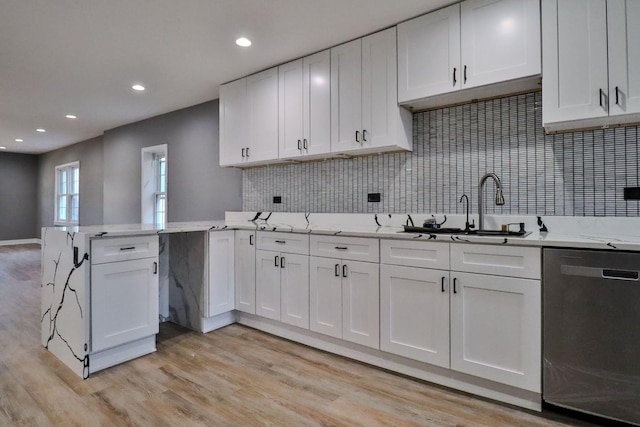 kitchen featuring white cabinetry, stainless steel dishwasher, light hardwood / wood-style floors, and sink