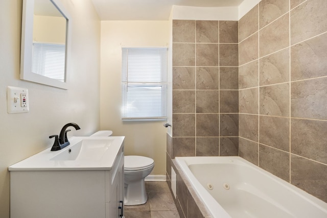 bathroom with a relaxing tiled tub, vanity, tile patterned flooring, and toilet