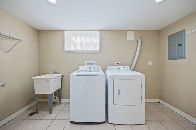 laundry room featuring electric panel, washer and dryer, and light tile patterned floors