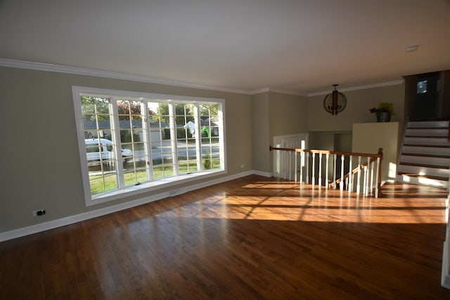 spare room with dark wood-type flooring, ornamental molding, and a wealth of natural light