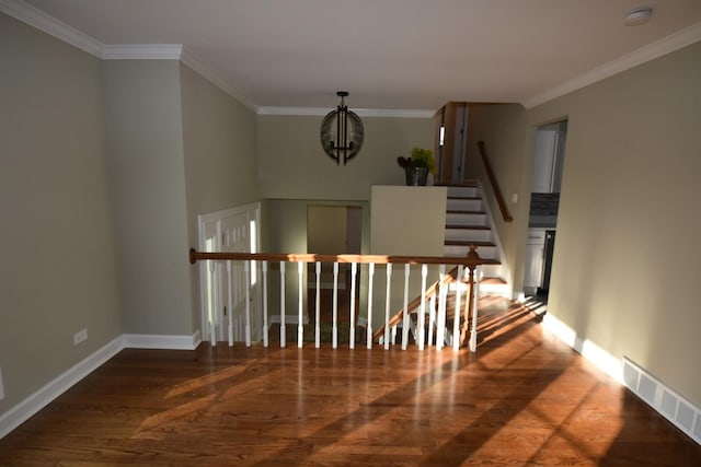 stairway with crown molding, wood-type flooring, and a notable chandelier