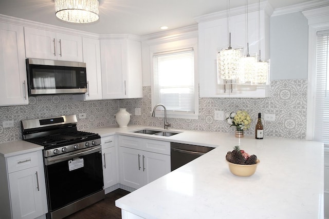 kitchen with pendant lighting, sink, backsplash, stainless steel appliances, and white cabinets