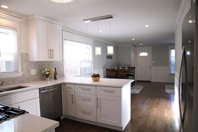 kitchen featuring white cabinetry, black fridge, kitchen peninsula, dishwasher, and pendant lighting