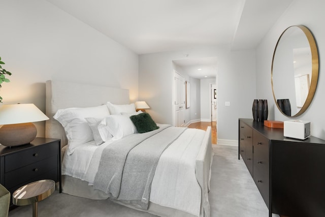 bedroom featuring baseboards and light colored carpet