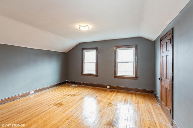 additional living space featuring lofted ceiling and light hardwood / wood-style flooring