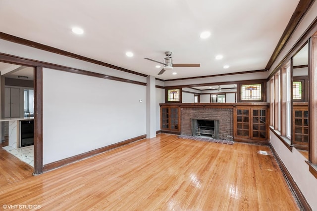 unfurnished living room with hardwood / wood-style flooring, ceiling fan, wine cooler, ornamental molding, and a brick fireplace