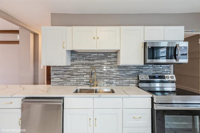 kitchen featuring white cabinets, stainless steel appliances, sink, and backsplash