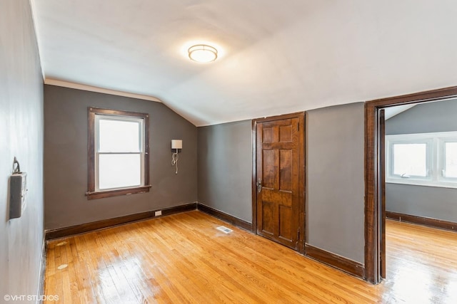 additional living space with lofted ceiling and light hardwood / wood-style flooring