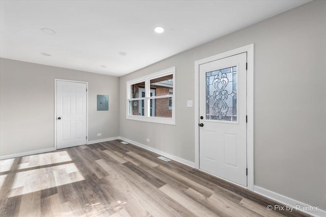 foyer featuring electric panel and light hardwood / wood-style floors