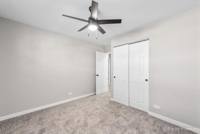 unfurnished bedroom featuring light carpet, a closet, and ceiling fan