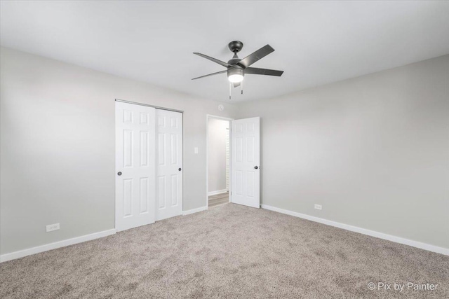 unfurnished bedroom featuring carpet, ceiling fan, and a closet