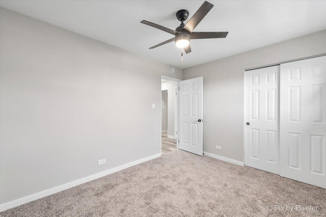 unfurnished bedroom featuring light carpet, ceiling fan, and a closet