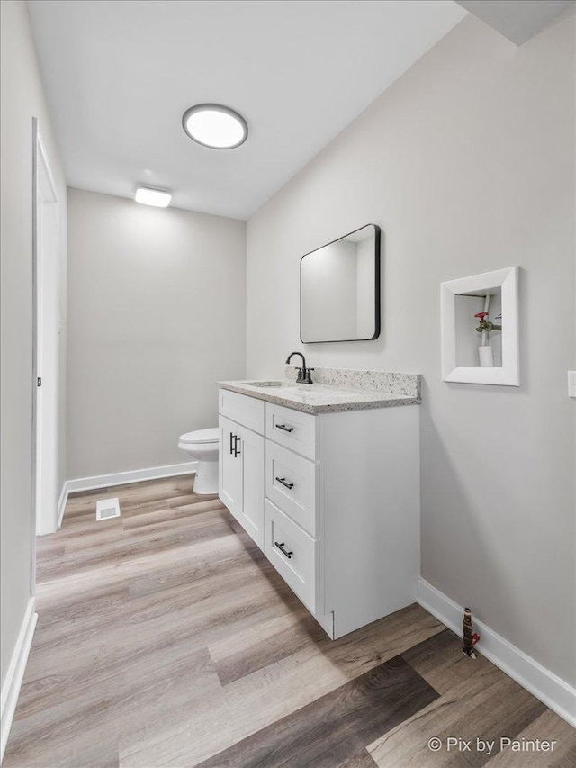 bathroom with vanity, hardwood / wood-style floors, and toilet