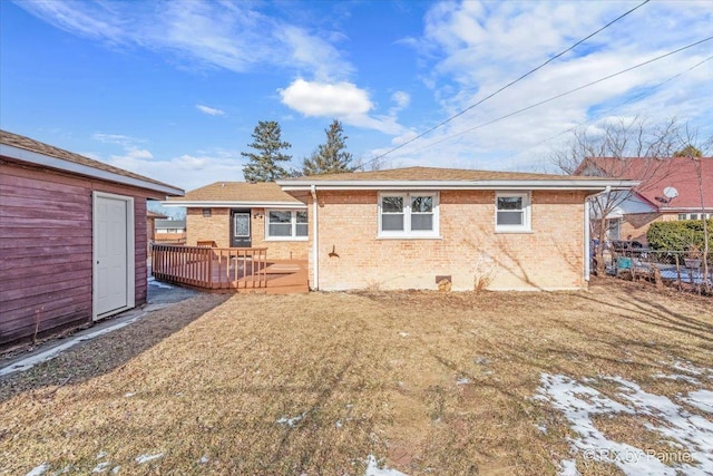 back of house featuring a wooden deck and a lawn