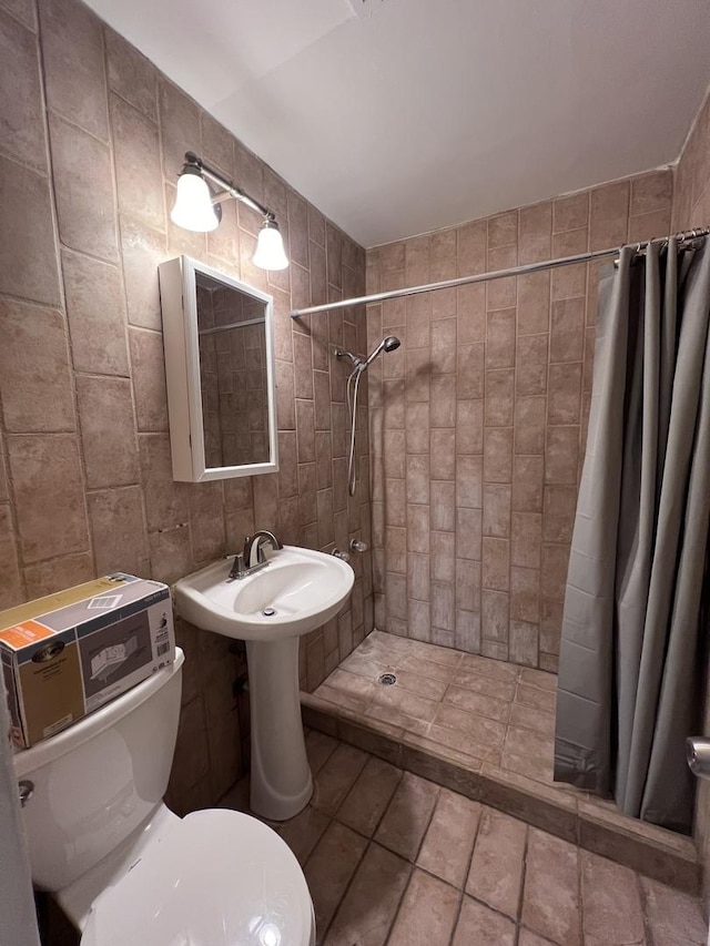 bathroom with toilet, tile walls, and walk in shower