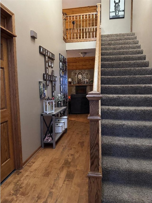 staircase with hardwood / wood-style flooring and a towering ceiling