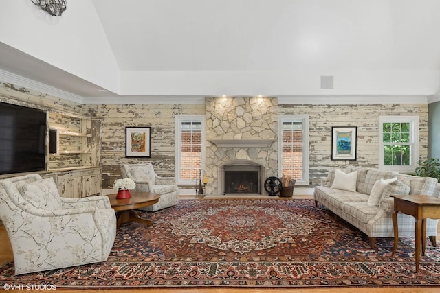 living room featuring crown molding, lofted ceiling, and a fireplace