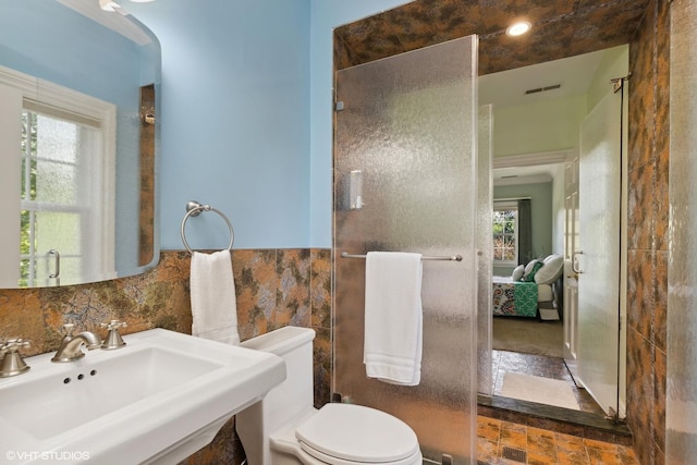 bathroom featuring a wealth of natural light, sink, tile walls, and toilet