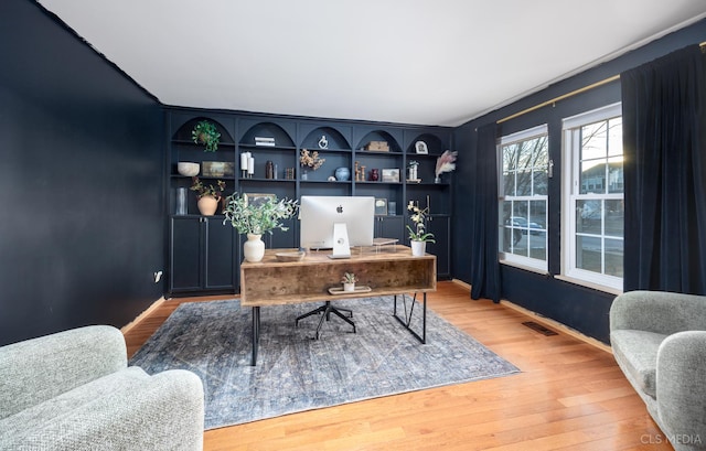 office area with hardwood / wood-style flooring and built in features